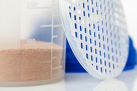 A measuring shaker with powder and a perforated lid